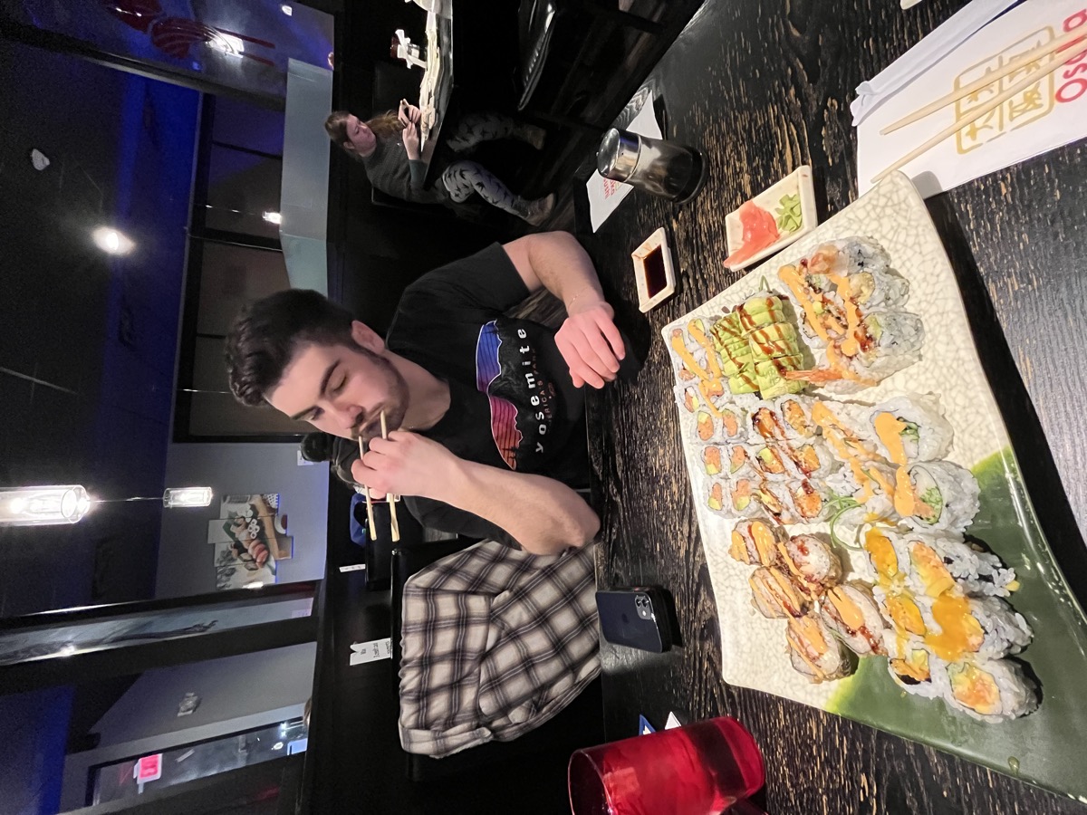 Matt Kahler eating from a giant platter of sushi rolls