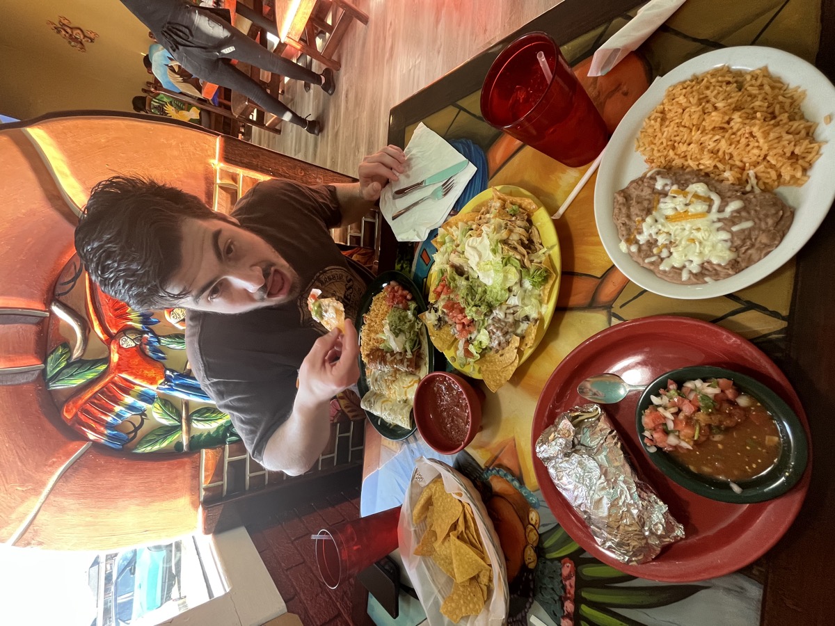 Matt Kahler diving into a table covered in Mexican food