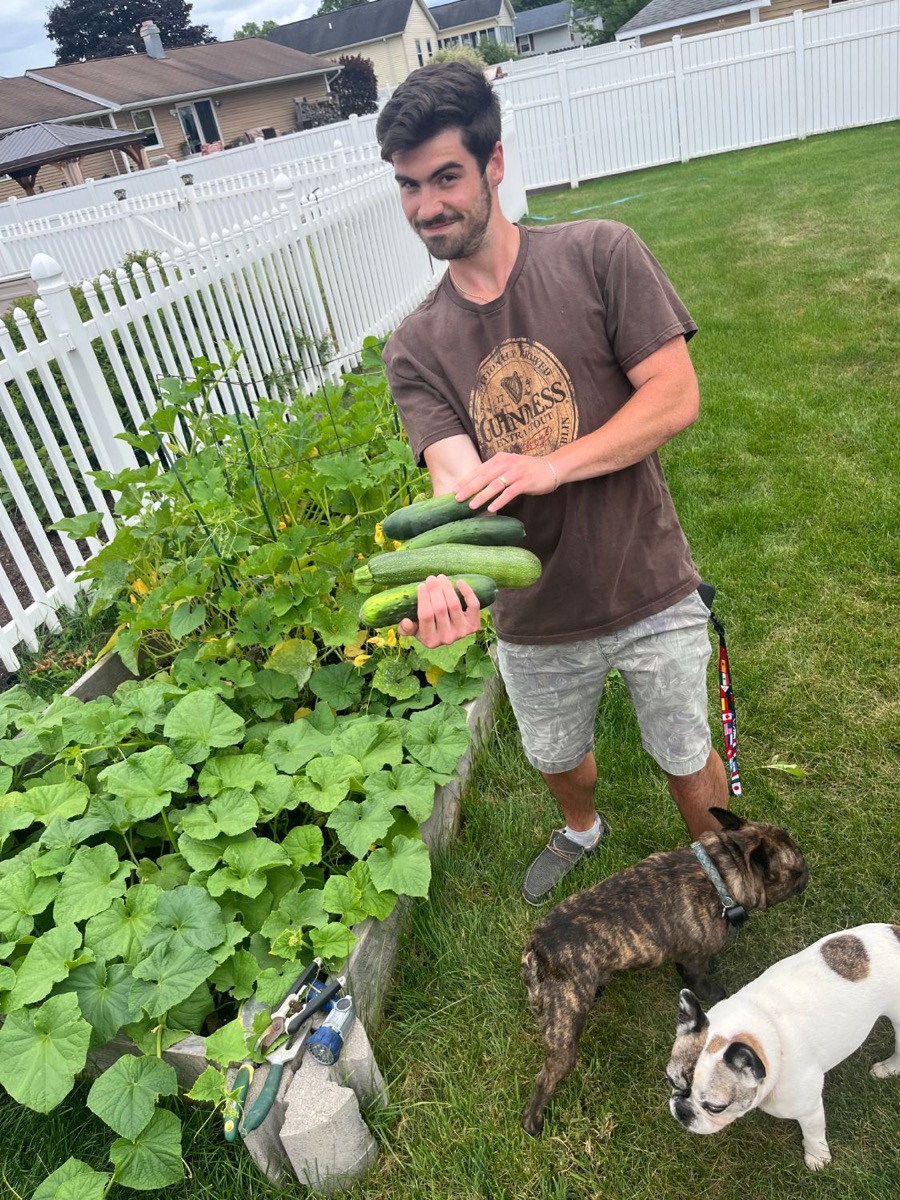 Matt Kahler holding an armful of homegrown cucumbers and zucchini