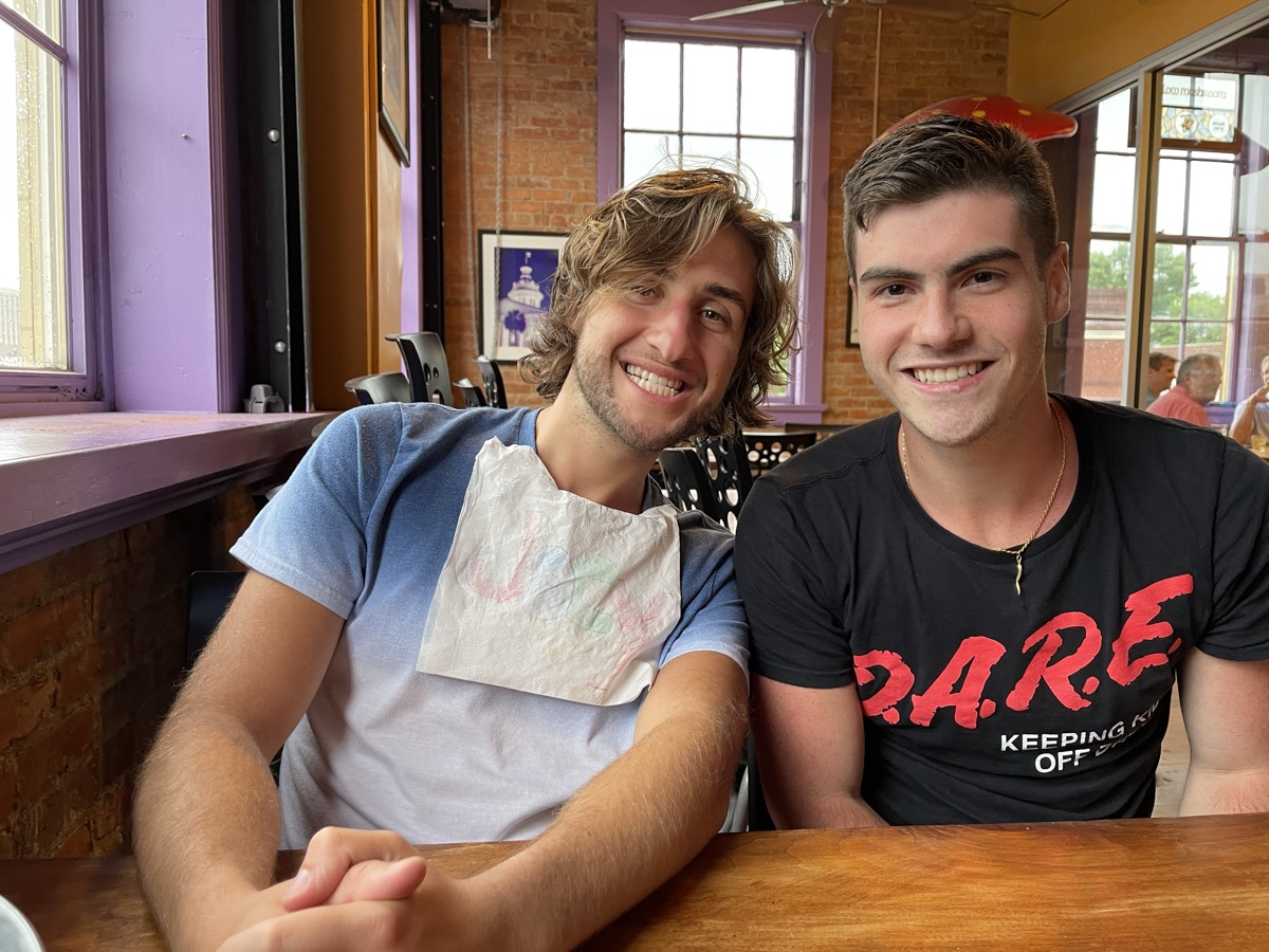 Matt Kahler in a D.A.R.E. shirt at lunch with a friend wearing a napkin bib